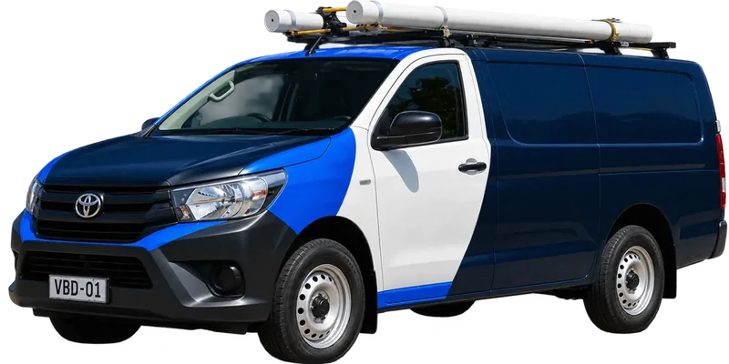 A licensed Kellyville plumbing van loaded with pipe on the roof rack